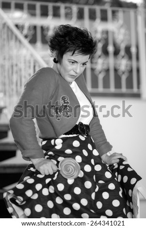 Photo session of an expressive, short haired, brunette woman with lollipop. Black and white photography