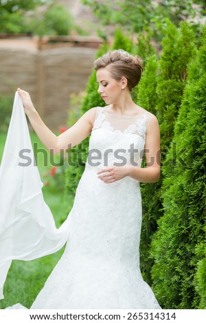 Beautiful, caucasian, long haired woman wearing a wedding dress with natural background