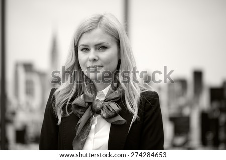 Blonde, expressive business woman looking pleased. Black and white photography