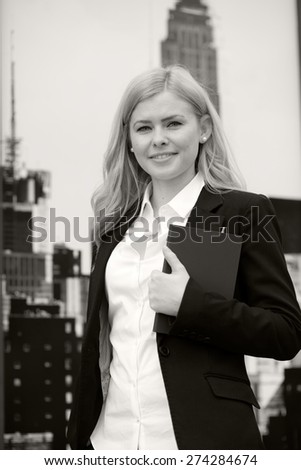 Blonde business woman with notebook and pen. Black and white photography