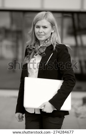 Blonde business woman with laptop. Black and white photography
