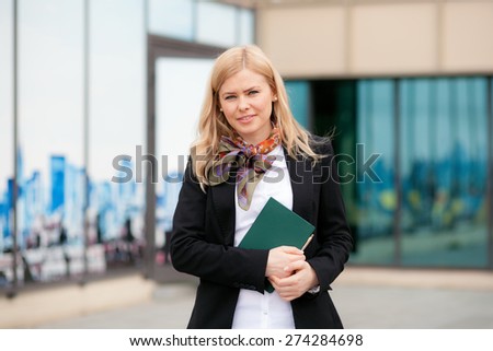 Blonde business woman with notebook and pen