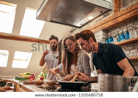 Shot of a group of friends cooking in the kitchen together