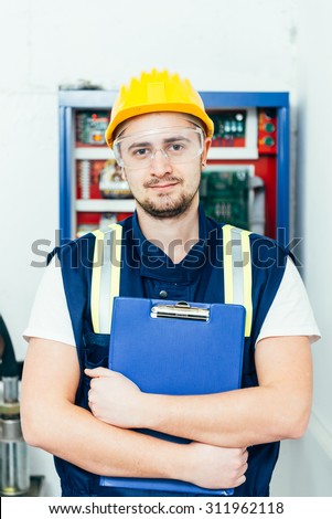 Young male electrician looking satisfied after finishing his job. Selective focus.