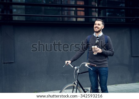 Shot of a young smiling businessman going to work by bike.