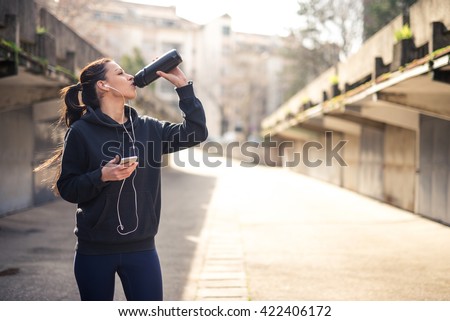 Beautiful girl setting a play list for running.