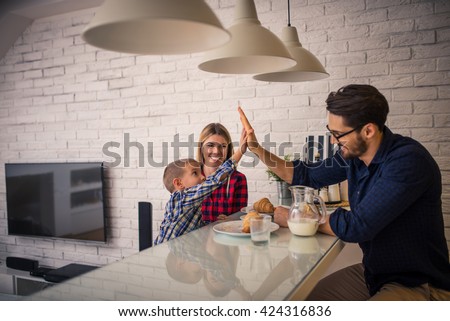 Giving high five to daddy while eating in the kitchen.