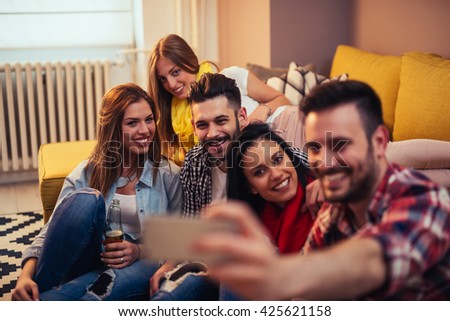 Friends making a selfie together at home party.