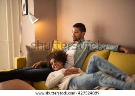 Couple relaxing at home and watching tv together.