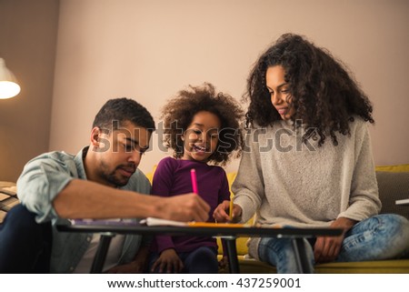 Parents drawing with their little girl.