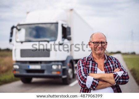 Portrait of a senior truck driver posing next to his truck.