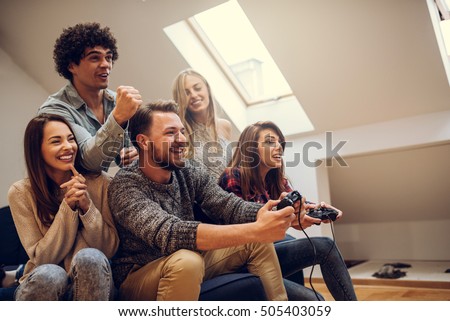 Group of friends playing digital games at home.