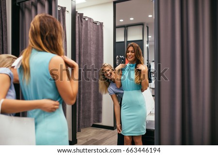 Photo of two young women trying out new clothes in the cabin.
