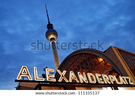 Night shot of the train station Berlin Alexanderplatz with the famous TV tower  in the background.