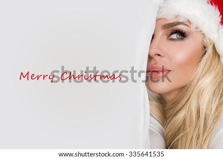 Beautiful sexy blonde female model dressed as Santa Claus in a red cap with a tassel at the White fur lovely makeup sensual lips, beauty photo Christmassy, Christmas