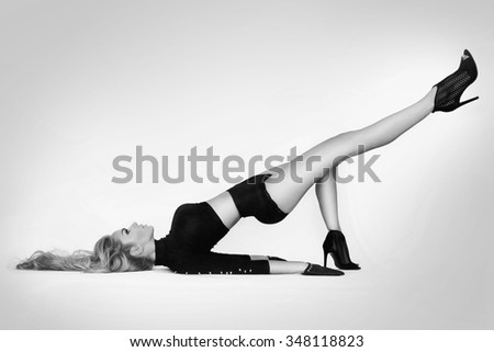 beautiful woman with long legs and blond long hair lies in difficult position,with raised leg