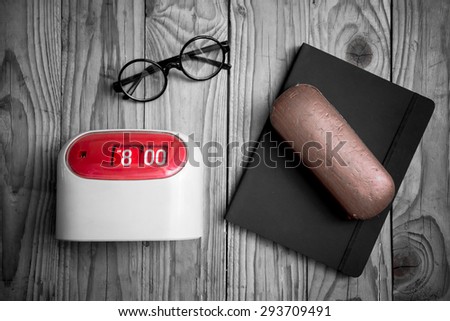 Working hours concept, Retro alarm clock at 8am with glasses and notebook in working time on wood backgroung