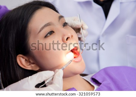 Medical treatment at the dentist office, Dentist and his assistant carrying out a thorough examination