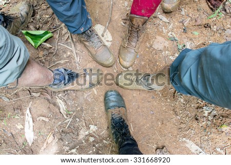 Hiking shoes on hiker in water puddle in rainforest. Man hikers hike boots in closeup. Male feet.