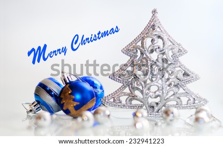 Festive ornaments. Blue, silver and golden Christmas decorations on white background. Glittering Christmas tree. Merry Christmas greetings.
