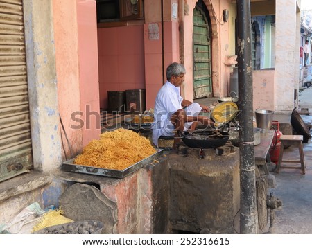 Nimaj, India - March 31st, 2013: Owner of a small food outlet cooking noodles in preparation for the morning rush of customers.