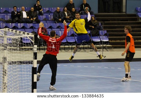 KYIV, UKRAINE - APRIL 2: Mykola Stetsyura of Ukraine (in yellow) attack the net during handball EHF EURO 2014 qualification game against Netherlands on April 2, 2013 in Kyiv, Ukraine