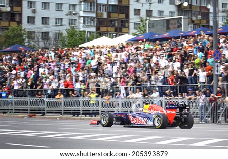 KYIV, UKRAINE - MAY 19, 2012: Daniel Ricciardo of Red Bull Racing Team drives RB7 racing car during Red Bull Champions Parade on the streets of Kyiv city