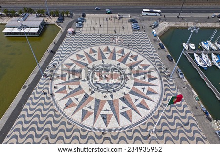 LISBON, PORTUGAL - JUNE 10, 2013: Mosaic map of the Portuguese discoveries and Wind-rose in grey, pink and orange marble bordered by typical Portuguese paving. Belem district of Lisbon city