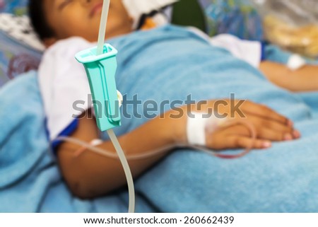 Closeup of infusion bottle with patient in hospital