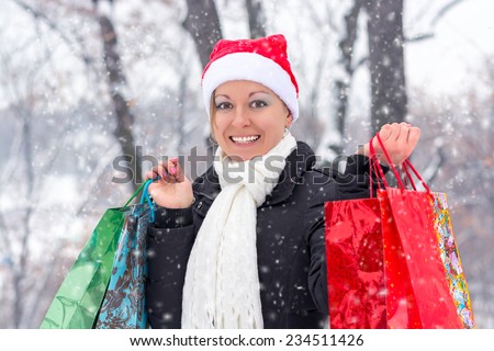 Happy woman in winter clothes with shopping bags before Christmas