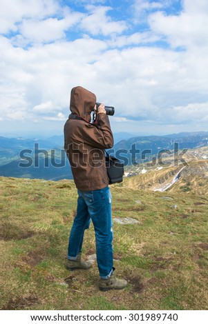 Photographer is shooting landscapes on a mountain top. View from the top of the mountain.