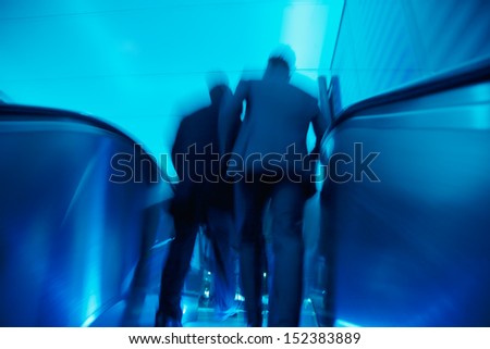 businesspeople on escalator in motion