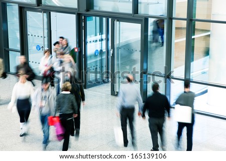people rushing through corridor