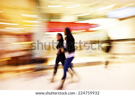 Young women walking past shop front window