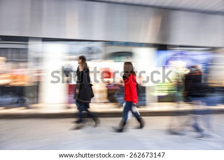 Shopper walking past a store window, zoom effect, motion blur