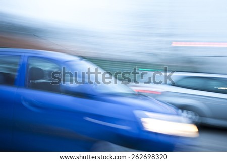 Blue car driving fast on country road, zoom effect