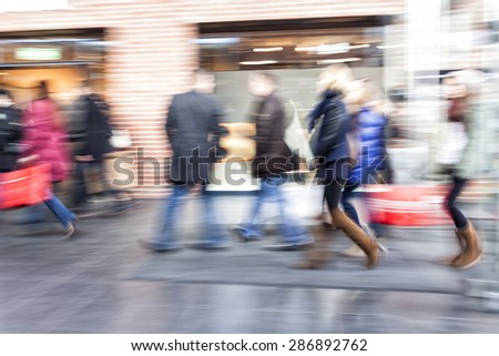 Group of people walking in shopping centre,  zoom effect, motion blur