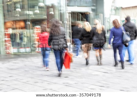 A shopper walking in front of shop window