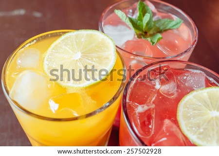three colored bright cocktail with mint and lemon on the wooden bar counter