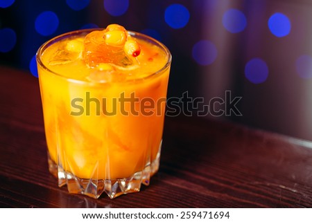 closeup cocktail orange and yellow sea buckthorn with a piece of ice