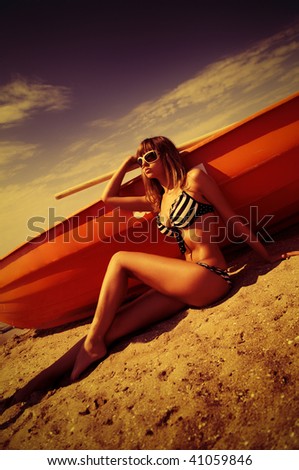 woman in bikini posing against sailor boat