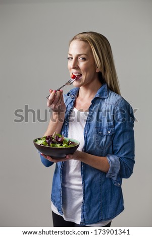 Healthy young woman enjoying a fresh green salad. Please view my portfolio for more images from this series.