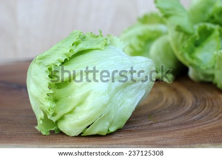 Green Iceberg lettuce on wooden background.