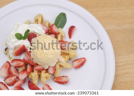 Belgian waffles with ice cream fresh strawberries and whipped cream.