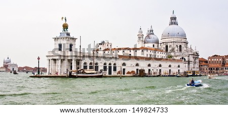 Dome of the basilica of Santa Maria della Salute and boats on the grand canal in Venice on a gray day