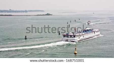 Boats depart from Venice to the open sea on a gray day