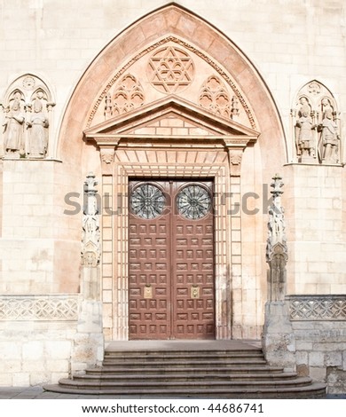 Front door to a religious building with angels to the sides