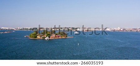 Island with houses and boats docked in Finland on a cloudy day with the capital into the fund