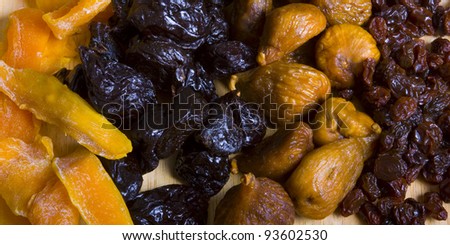 Collected four different kinds of dried fruits: raisins, prunes, figs, and mango