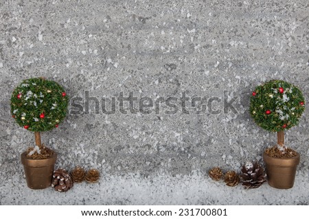 Decorated christmas tree ornament on grey stone background with fake snow